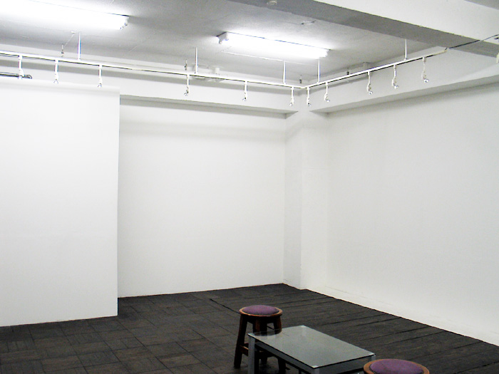 Há uma parede branca entre a exposição de fotografia e uma exposição fotográfica